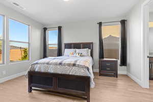 Bedroom with baseboards, visible vents, and light wood-type flooring