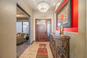 Foyer featuring an inviting chandelier, wood finished floors, and baseboards