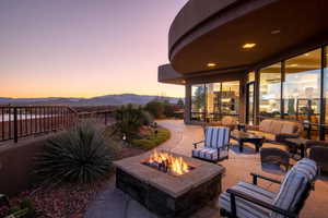 Patio terrace at dusk featuring an outdoor living space with a fire pit, fence, and a mountain view
