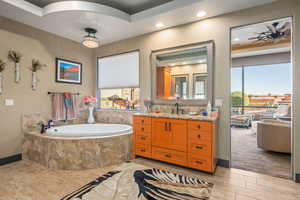 Full bathroom featuring wood finished floors, a bath, vanity, baseboards, and recessed lighting