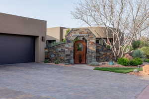 View of front of property with stucco siding, decorative driveway, and a garage