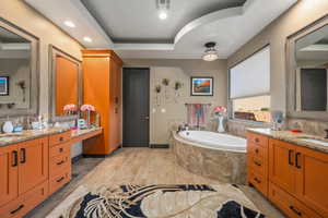 Bathroom featuring a bath, visible vents, recessed lighting, and vanity