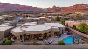 View of pool with fence, a patio area, a pool with connected hot tub, and a mountain view