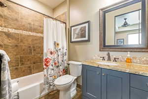 Full bath with tile patterned flooring, toilet, vanity, and shower / bathtub combination with curtain