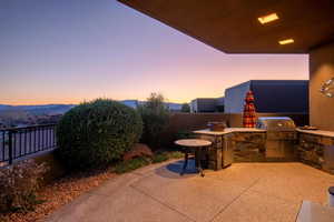 View of patio with area for grilling, a grill, and fence