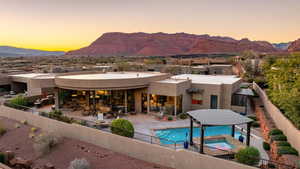 Back of house with a patio area, a fenced backyard, a mountain view, and stucco siding