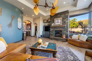 Living room featuring wood finished floors, arched walkways, recessed lighting, and a raised ceiling