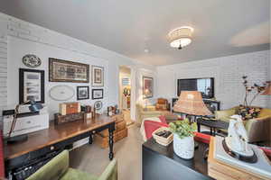 Office with carpet and brick wall