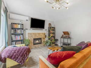 Living room with a fireplace, a wall mounted air conditioner and air filtration system.