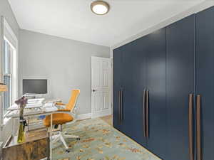Bedroom set up as an office area with storage cabinet.