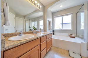Full bathroom featuring a shower stall, a garden tub, tile patterned floors, and a sink