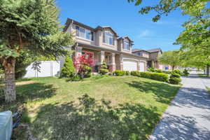 View of front of property with a porch, fence, a garage, a front yard, and stucco siding