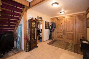 Entrance foyer with a textured ceiling and stairway