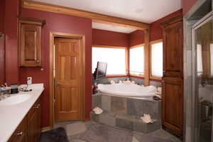 Bathroom featuring a bath, vanity, and a stall shower