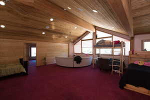 Bedroom featuring wood ceiling, carpet, and multiple windows
