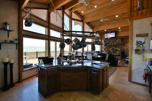 Kitchen with wood ceiling, dark countertops, a sink, and high vaulted ceiling
