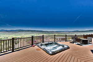 Wooden terrace with hot tub deck surround and a mountain view