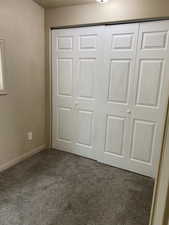 Unfurnished bedroom with baseboards, carpet floors, and a closet
