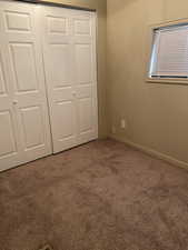 Unfurnished bedroom with carpet floors and a closet
