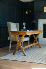 Dining room with wood finished floors, visible vents, and a tile fireplace