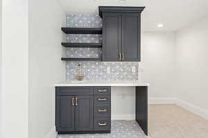 Bar featuring baseboards, a sink, and tasteful backsplash