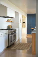 Kitchen featuring light countertops, open shelves, wood finished floors, double oven range, and built in shelves