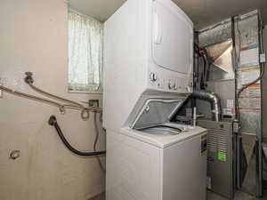 Clothes washing area featuring stacked washer / dryer and laundry area