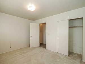 Unfurnished bedroom with a closet and light colored carpet