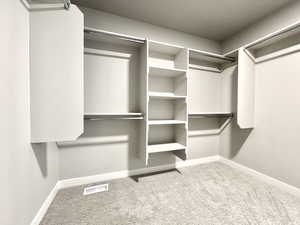 Walk in closet with visible vents and carpet floors