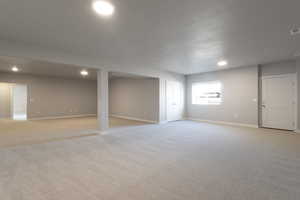 Below grade area featuring visible vents, baseboards, recessed lighting, and light colored carpet