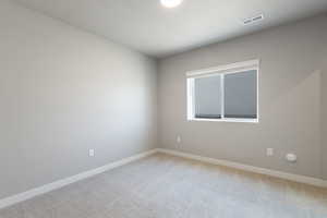Empty room with baseboards, carpet flooring, and visible vents