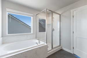 Full bathroom featuring tile patterned floors, a garden tub, and a stall shower