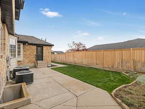 View of yard with a fenced backyard, central AC, a patio.