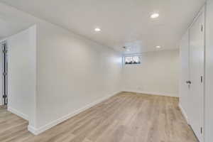 Basement with light wood-type flooring, recessed lighting, and baseboards