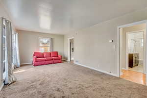 Carpeted living room featuring visible vents and baseboards