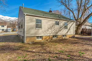 Rear view of house featuring fence, a chimney, and a mountain view