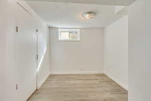 Below grade area with light wood finished floors and baseboards
