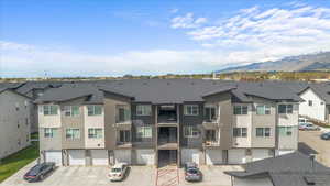 View of building exterior featuring a residential view, a mountain view, and an attached garage