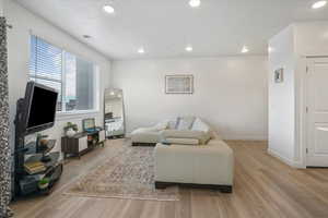 Living room featuring visible vents, recessed lighting, light wood-style flooring, and baseboards