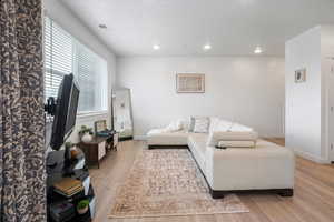 Living room featuring recessed lighting, visible vents, wood finished floors, and baseboards