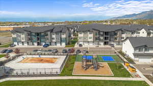 Birds eye view of property with a mountain view and view of amenities. Pool, Pickleball court and playground.