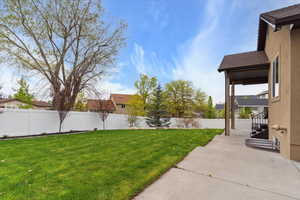View of yard featuring fence and a patio area