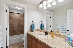 Full bathroom with toilet, vanity, and tile patterned flooring