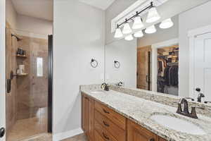 primary bathroom with custom tiled oversized shower and double vanity