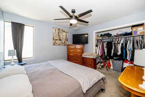 Bedroom with carpet flooring, a ceiling fan, and a closet