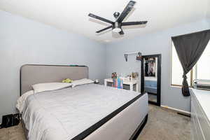 Bedroom with baseboards, ceiling fan, and light colored carpet