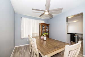 Dining space featuring baseboards, a ceiling fan, and light wood finished floors