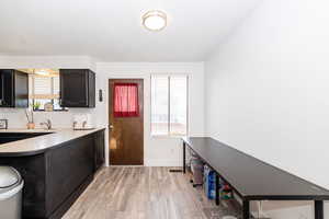 Kitchen featuring light wood finished floors, baseboards, a wealth of natural light, and tasteful backsplash