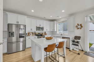 Kitchen featuring a sink, stainless steel appliances, light countertops, and light wood-style floors