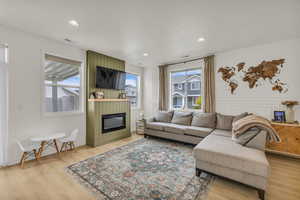 Living room with a fireplace, recessed lighting, and light wood-type flooring